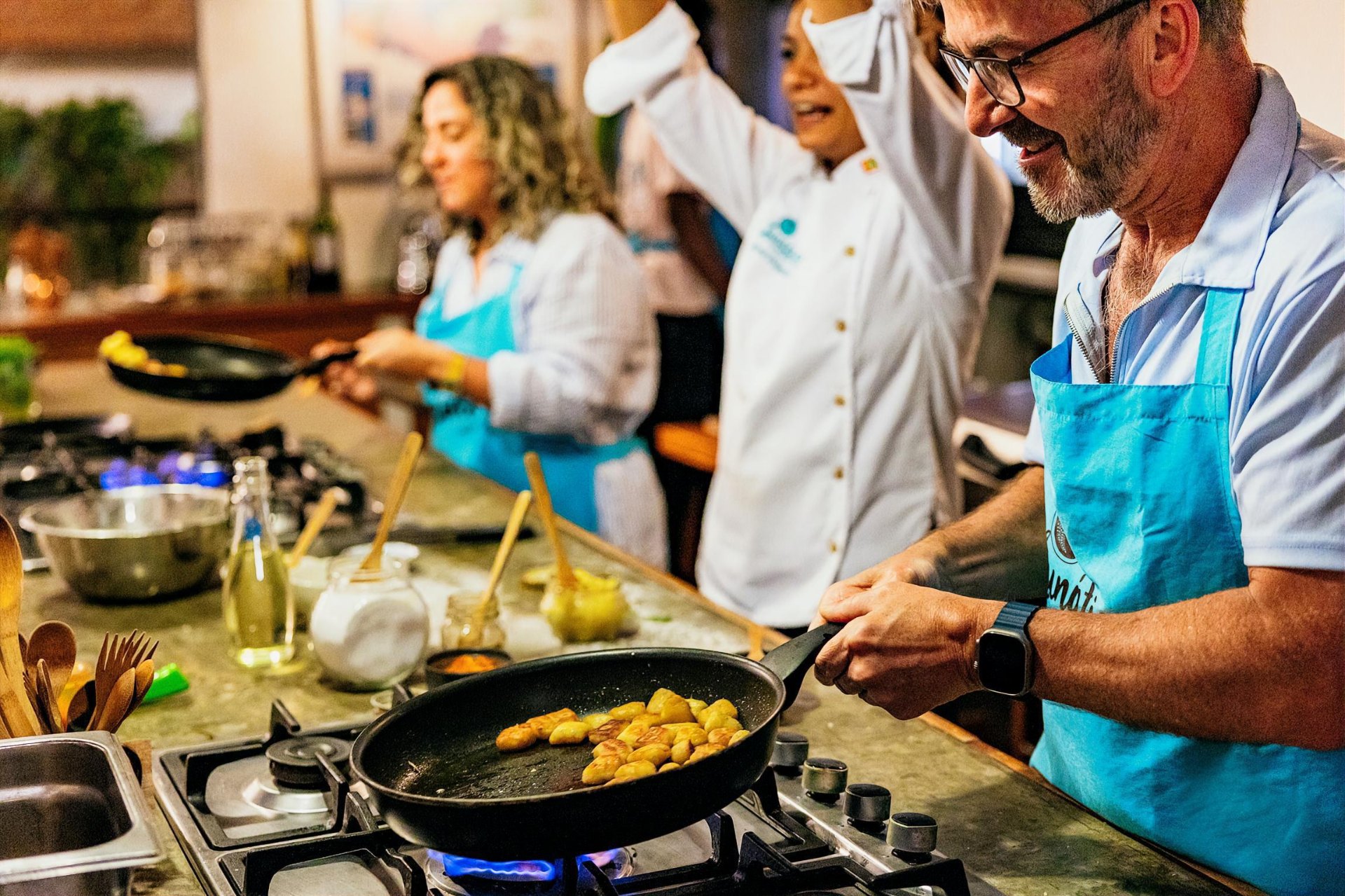 Participante cocinando plátanos en una clase de cocina colombiana